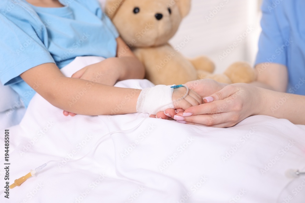 Naklejka premium Doctor examining little child on bed in hospital, closeup