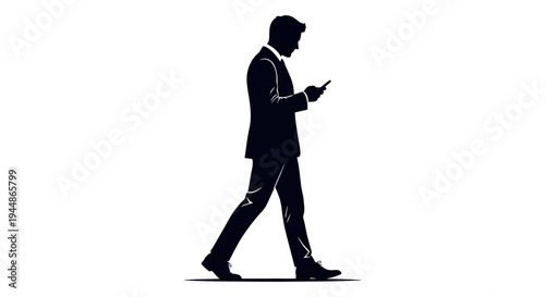 Silhouette of a businessman walking while looking at his smartphone.