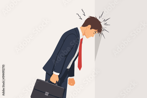 Stressed businessman in a dark suit and red tie banging his head against a wall in frustration, anger, and despair. Professional man feeling overwhelmed, burnt out, and desperate at work.