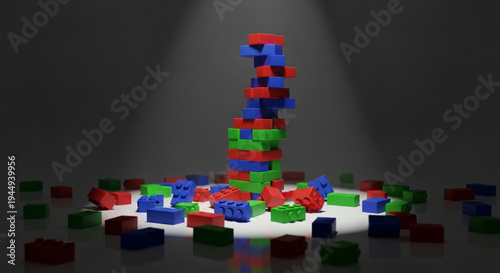 A precarious stack of red, blue, and green building blocks standing under a dramatic spotlight, representing instability, risk, or creative construction.