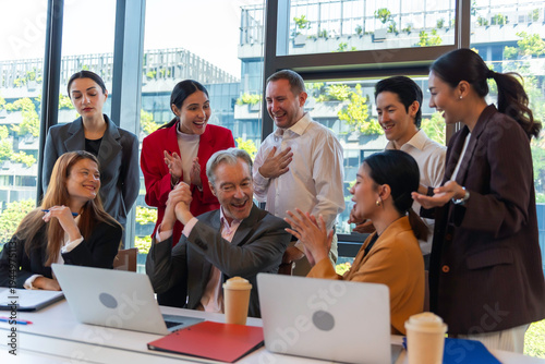 фотографія Multiracial euphoric business team people give high five at office table with laptop, happy excited diverse work group engaged in teambuilding celebrate corporate success win partnership power