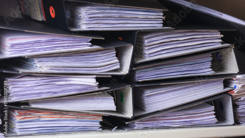 фотографія Heavy stack of paperwork binder document showing stressful workplace safety risk