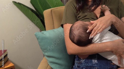 Nurturing Young Mother  breastfeeding newborn infant in chair