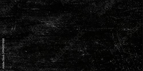 A macro closeup of rain drops on a black glass surface creates a dark textured pattern with a grunge wallpaper design on a rough gray backdrop