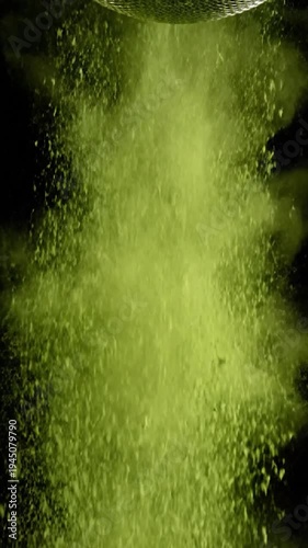 Fine green powder is sifted through a sieve against a dark background