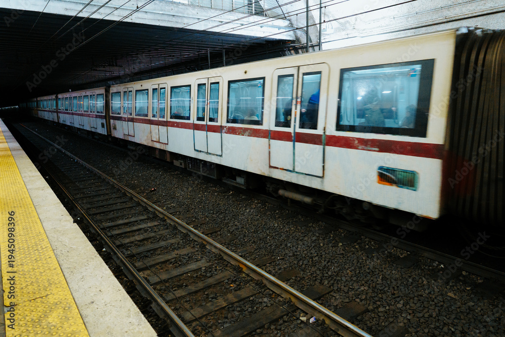 Fototapeta premium Train arrives at underground station during busy commuter hours in the city