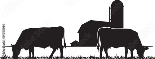 Black silhouette of two cows grazing in front of farm buildings