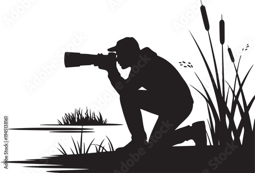 Silhouette of photographer kneeling by water with cattails and grass