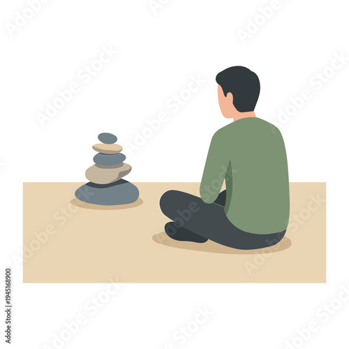 A man sits cross-legged on the floor looking at a stacked stone pyramid