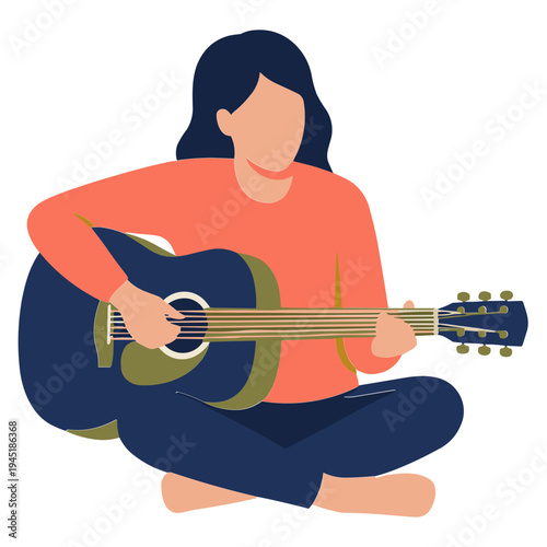 A woman plays an acoustic guitar while sitting cross-legged indoors.