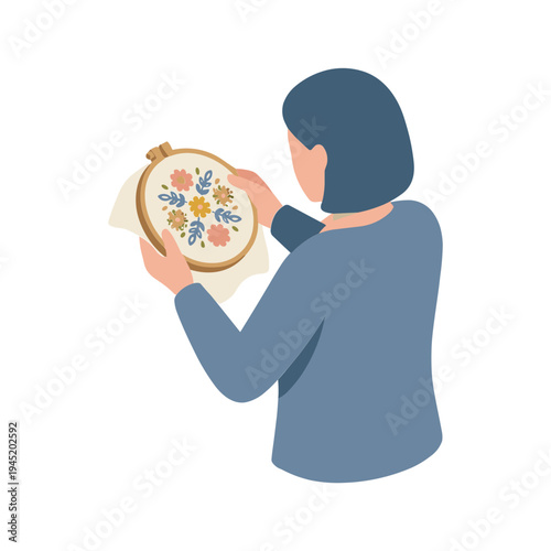 Woman holds embroidery hoop with colorful flowers on fabric indoors