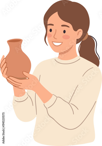 Woman holding and smiling at a clay vase in her hands indoors