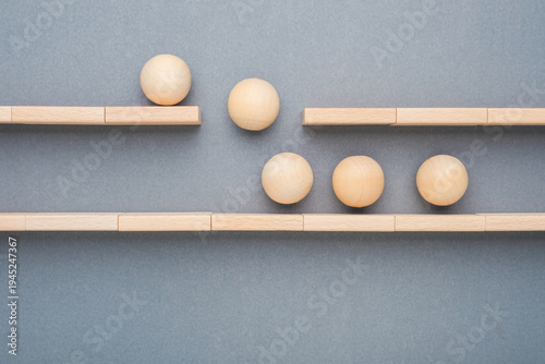 Wooden balls changing path to new track, adaptation and new direction concept