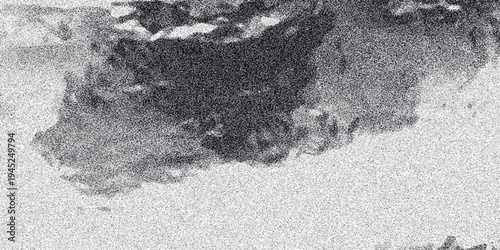 Abstract grayscale dark cloud formation with grainy texture and diffused light creating a dramatic or stormy atmospheric background