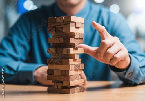 Businessman playing Jenga, symbolizing risk and strategy in modern office