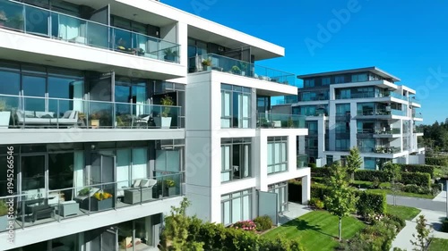 Modern apartment complex with glass balconies and landscaped gardens. Exterior view of a new residential building for real estate and urban development concepts
