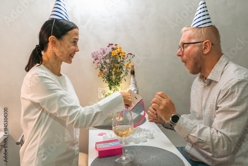 Photography Couple Birthday Party Celebration: Indoor intimate birthday celebration; man woman exchanging gifts; joyful mood