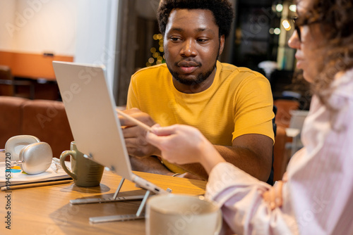 Man in wheelchair and woman colleague discussing online project