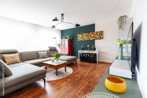 Wallpaper Mural cozy living room with a large gray sofa, wooden flooring and a dark green accent wall. modern and colorful style decorated with wood wall art Torontodigital.ca