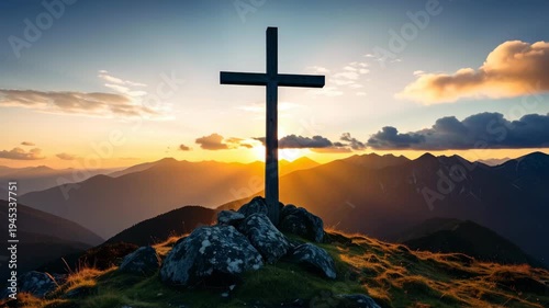 Wooden cross on a rocky mountain top at sunrise with golden sunlight shining over distant peaks