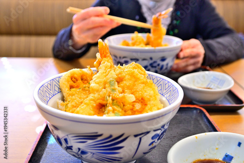 日本食の天中を食べる女性