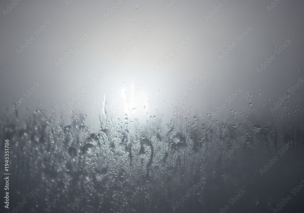 Obraz premium Condensation forming on a window pane with diffused light shining through the mist