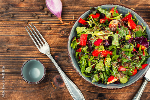 Fresh garden salad with seeds served in a ceramic bowl.