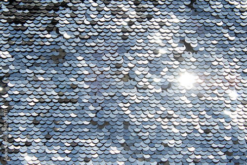 Silver sequin texture with shimmering sparkle and reflective metallic surface for design