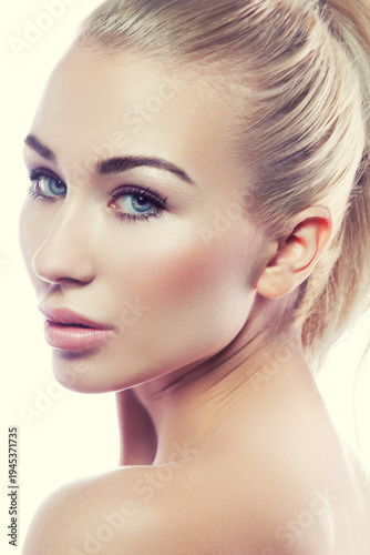 Beauty face of young caucasian model girl with natural day nude makeup, clean skin and slick hair, blue eyes. Skincare health facial treatment concept