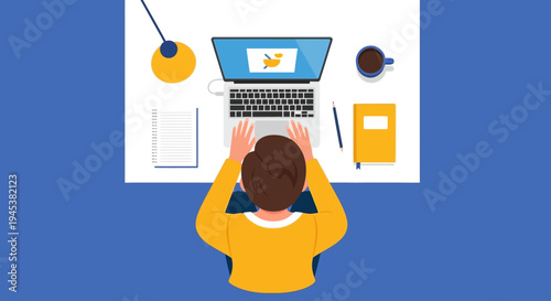 Overhead view of a person working on laptop at desk with office supplies.