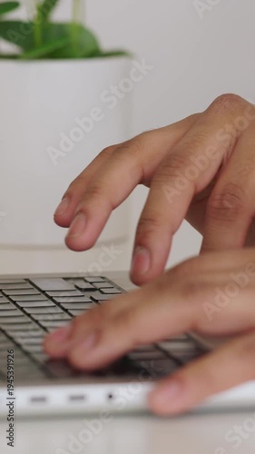 Vertical HD video of close up hands typing on laptop keyboard in home office workspace. Detailed view of digital work and online communication. Technology concept.