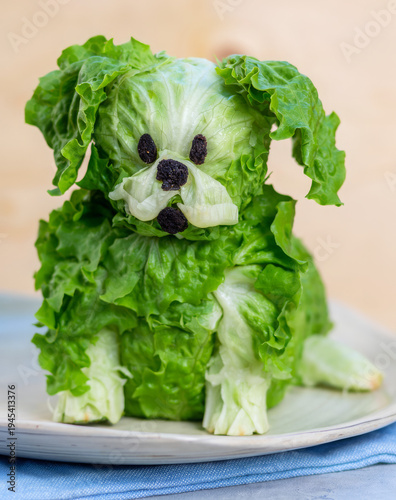 Cute dog made from fresh green lettuce and black olive for vegan food