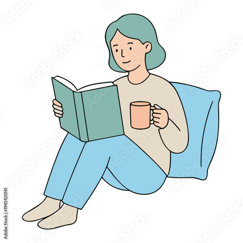A woman sits on a couch reading a book with a cup