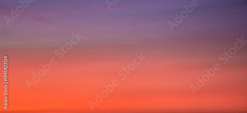 Abstract nature painting on the sky featuring a beautiful blend of orange, purple, and yellow light across layered evening cloud formations