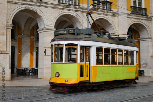Billede på lærred Colorful, lime-green, vintage tram line 25 operating in the central Lisbon district in Portugal