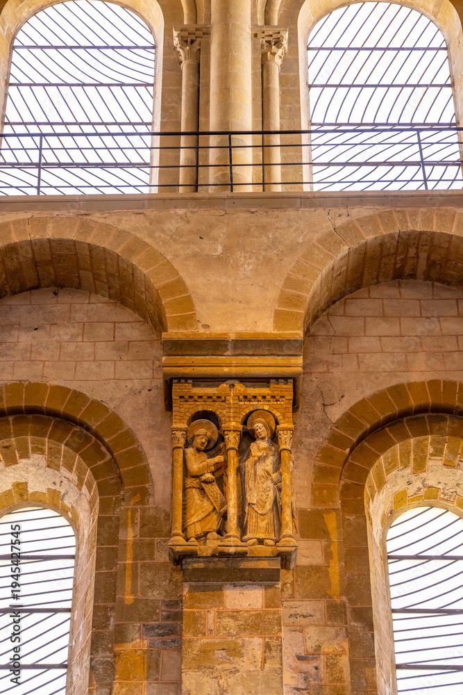 Naklejka premium Romanesque stone carving depicting Mary and angel Gabriel inside Conques Abbey