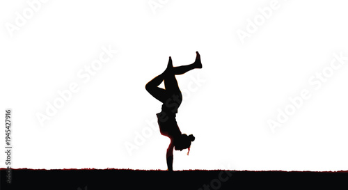 Silhouette of an athletic female dancer demonstrating impressive strength and balance while performing a perfect one-handed handstand against a bright white background outdoors.