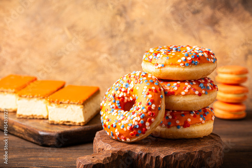 Glazed orange donats and tompouce dessert with Dutch event Kings day in background. National holiday Koningsdag on 27 April in the Netherlands. Holland culture concept with copy space