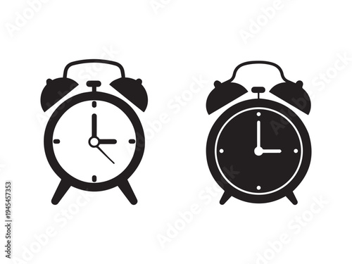 Two black and white alarm clock icons side by side showing different clock face designs  one with white face and black hands and one with black face and white hands