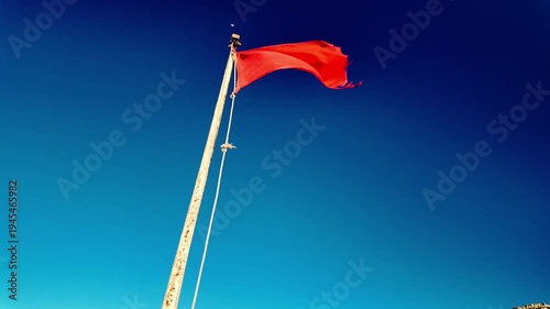 Red flag flies on the beach, symbolizing the rough sea and the ban on bathing.