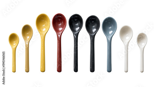 A vibrant collection of ceramic measuring spoons in various colors arranged neatly in a row on a transparent background.