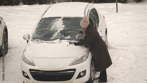 Odśnieżanie zasypanego śniegiem samochodu w okresie zimowym