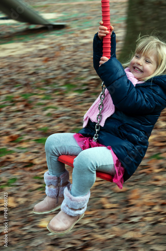 little blonde girl having fun on the zipline