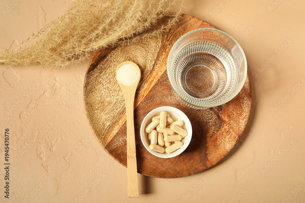 Obraz premium Spoon with collagen powder, pills and glass of water on beige grunge background