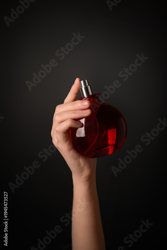 Female hand with red bottle...