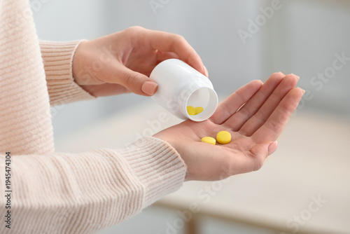 Young woman taking vitamin ...