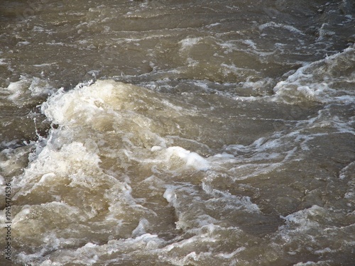 Bild auf Leinwand Raging Brown Water Surges Through Landscape
