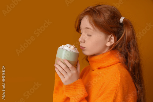 Teenage redhead girl drinki...
