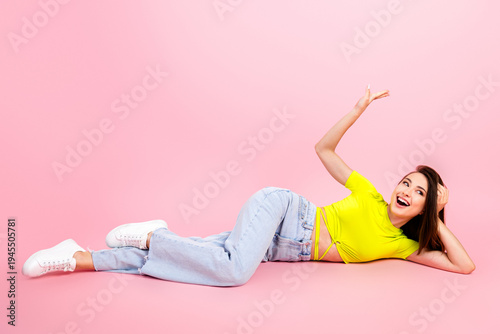 Fotografie Happy woman reclining on pink background in casual fashion outfit smiling confid
