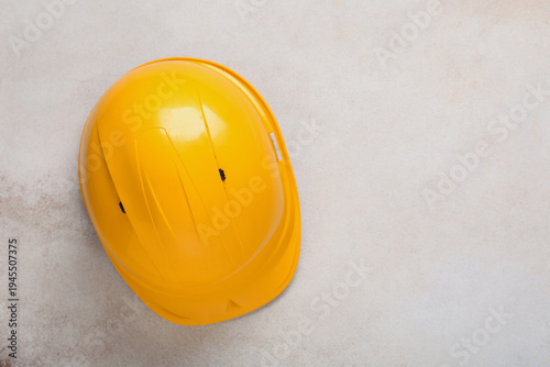 Yellow hardhat on beige gru...
